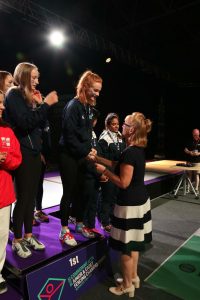 Ruth Robson giving medal to podium in fencing competition