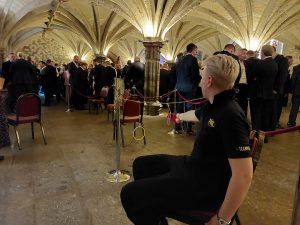 A PGL coach sitting in the magnificent crypts of the London Guildhall holding a plastic fencing sword 