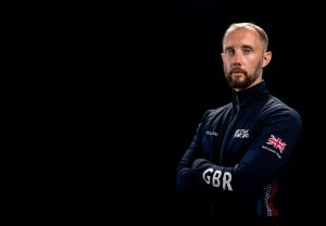 A portrait of a GBR coach with their arms folded.