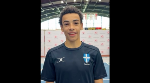 A fencer smiles to the camera.