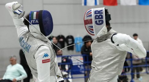 Two foil fencers in action, one representing Italy and the other GBR.