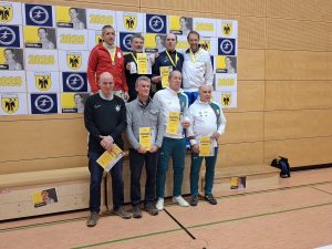 Several fencers on a podium holding certificates.