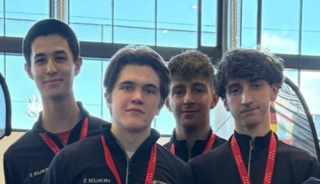 GBR Mens Junior Foil team faces together with medal ribbons showing around their necks. David Sosnov, Callum Penman, David Kelly and Mohammed Belbouab