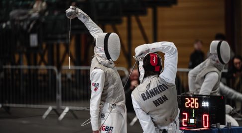 Two foil fencers in action, one representing GBR and the other Hungary.