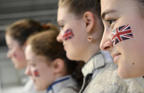 Side profile photo of four fencers with the GBR flag on their face.
