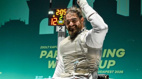 A GBR foil para fencer cheers and raises their fist after a win