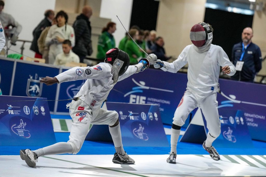 Two epee fencers in action, one representing GBR and the other Austria.