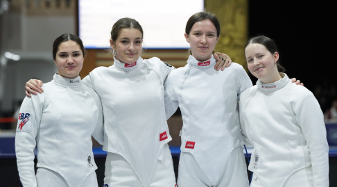 Four GBR epee fencers smile to the camera.