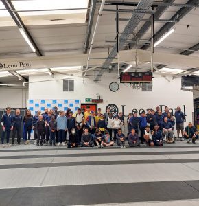 Large group photo in front of the Leon Paul sign