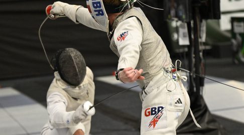 Two foil fencers in action, one representing GBR