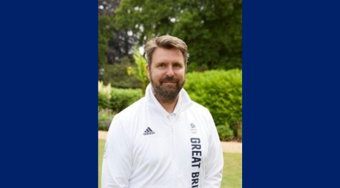Chris Price smiling to camera outside with green trees behind him. Image credit BOA