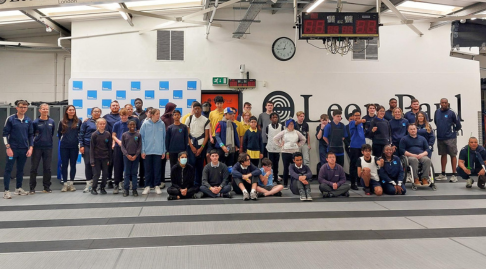 Large group photo in front of the Leon Paul sign