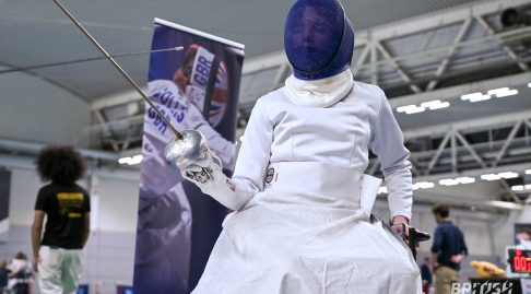 A photo of a wheelchair fencer at a competition.