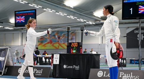Two young epee fencers test weapons at a competition.