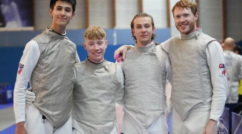 Four GBR foil fencers smile to the camera