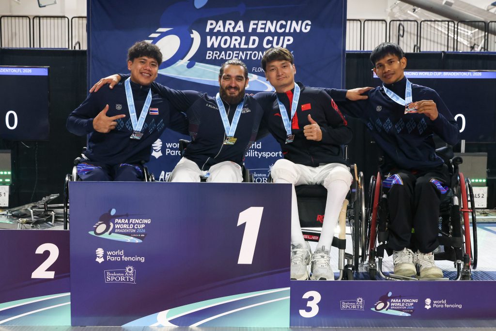 Four para fencers are on a podium smiling to the camera, each wearing a medal. L-R: THA, GBR, CHN, THA.