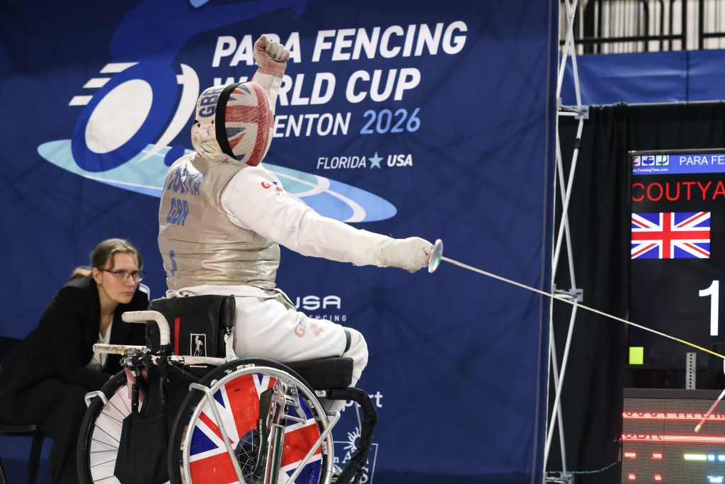 A GBR foil para coach raises his fist in celebration.