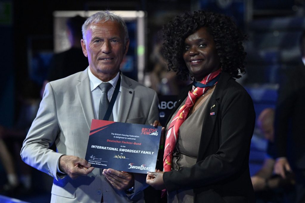 Pat Aiyenuro presents SwordSeat family certificate to the President of the German Fencing Federation